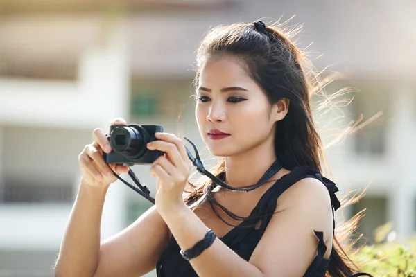 Beautiful woman photographer with a compact camera