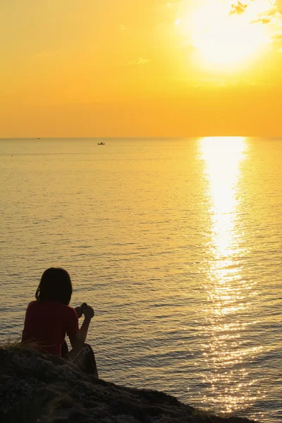 Young lady sea coast and enjoying sunset