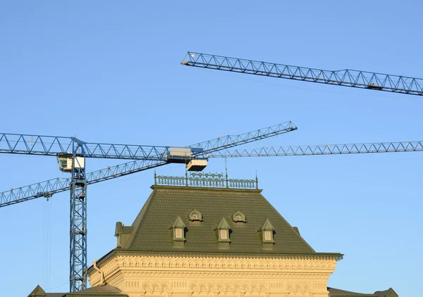 Cranes above the building roof.