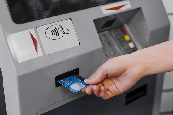Woman hand  put credit card into ATM