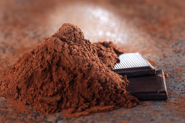 Chocolate pieces and cocoa powder on a stone table