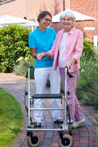 Care assistant helping elderly lady