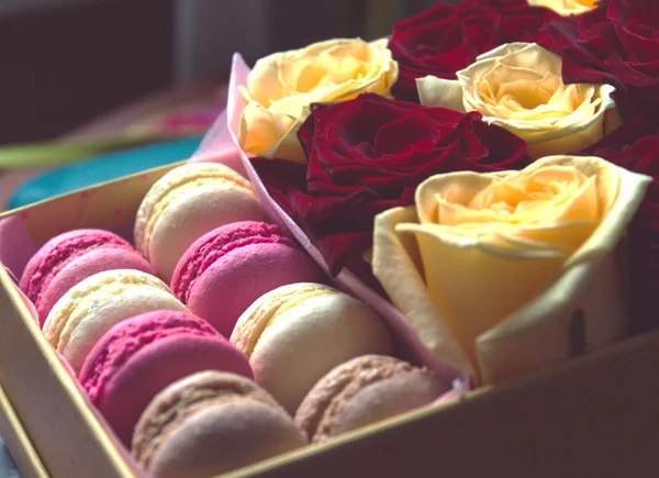 Macaroon and box with flowers roses background