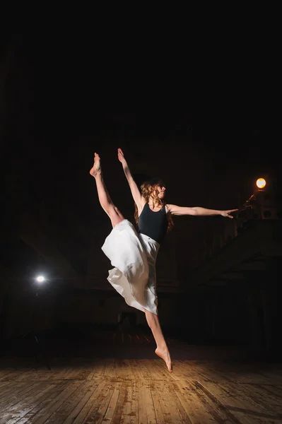 Young brunette dancer girl in split jump