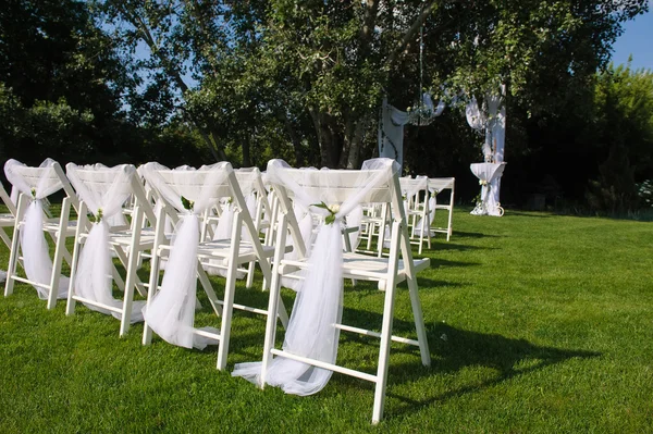 White decorated chairs on a green lawn