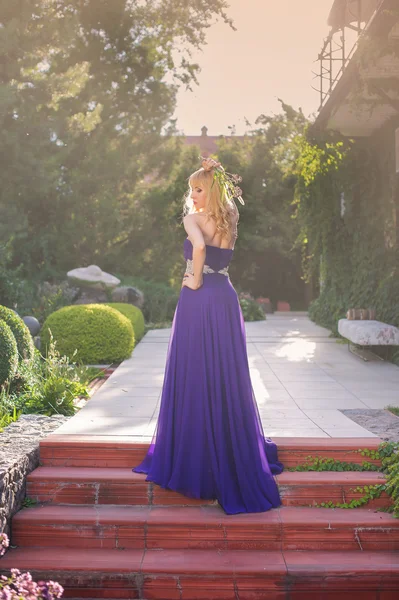 Woman wears long purple dress.