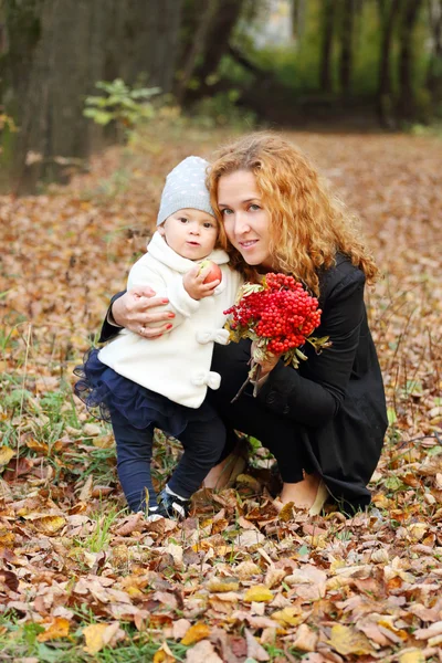 Beautiful woman with little daughter and rowanberry