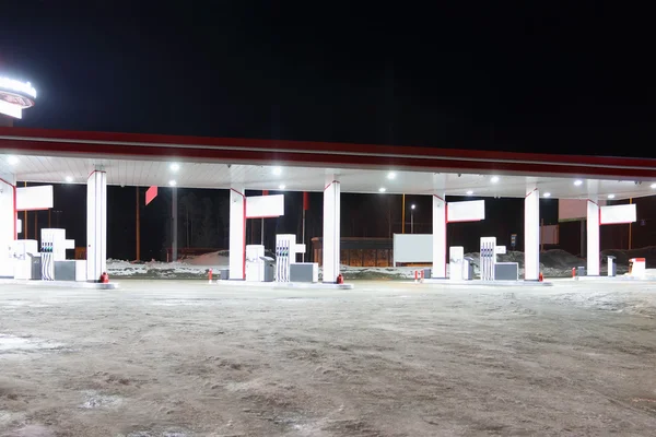 Empty petrol station with illumination at dark winter night