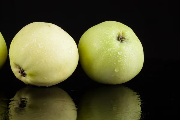 Summer green apples on a black background