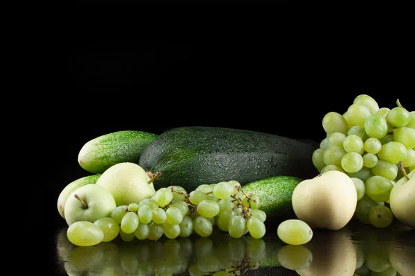 Fruits and vegetables on a black background, apple, cucumber, apricot, grapes, zucchini, peaches