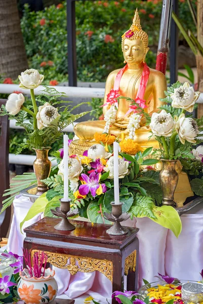 Buddha statue wet water with flower. Usually, Thai people will decorate The Buddha with flowers for Songkran Festival, Water Festival