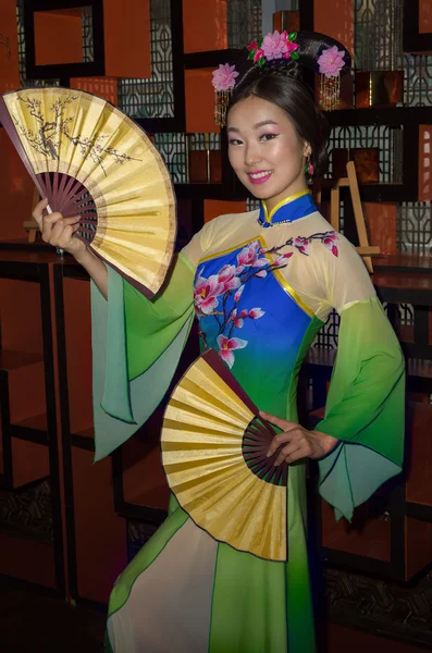 China Girl, Chinese woman blue and green traditional cheongsam, close up portrait with funs