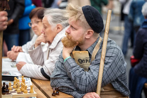 Moscow, Russia - September 11, 2016: the celebration of 869 years of the city of Moscow.  Historical reconstruction -  Soviet pensioners on a bench playing chess and reading the newspaper Pravda