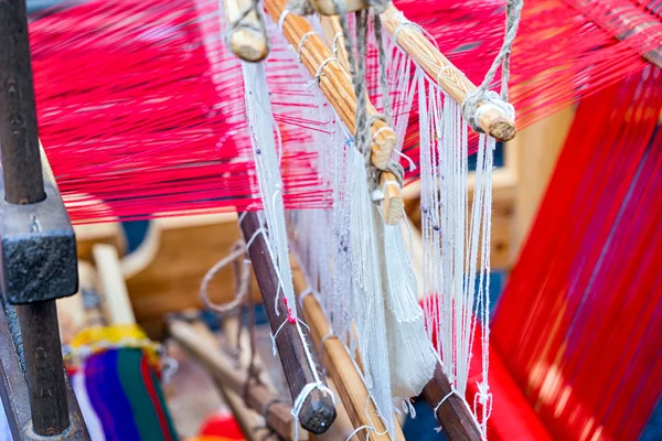 Weaving loom and shuttle on the warp.