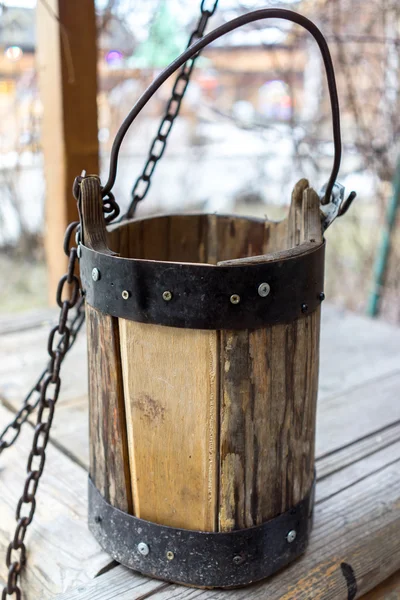 Detail of old draw well with wooden bucket on a metal chain close up view in Izmailovo Kremlin, Moscow, Russia