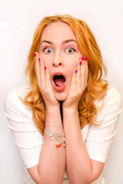 Close up portrait of a young caucusian woman with curly ginger hair scared afraid and anxious. Screaming with eyes wide open. Human emotions. Parody on a Munch Scream. Isolated on a white background.