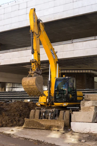 Moscow, Russia April 11, 2015: Modern JCB excavator machinery performs excavation work near the construction, Utility machine used for soil work.