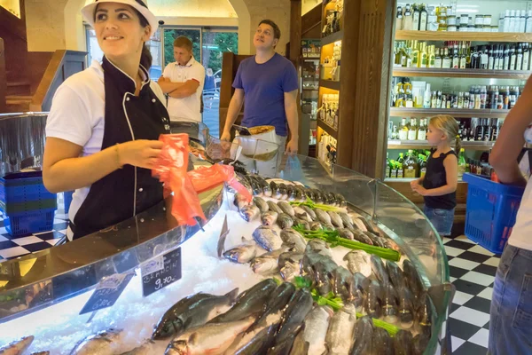 KOTOR, MONTENEGRO - SEPTEMBER 02, 2015: Unidentified sellers pack the fishes at their popular COGImar fish shop.
