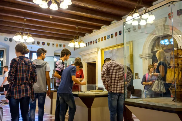 KOTOR, MONTENEGRO - SEPTEMBER 10, 2015: Maritime Museum of Montenegro. Visitors looking at the exponates in the museum hall.