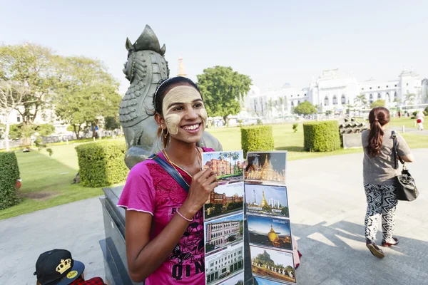 An ethnic minority woman sell postcard in a center park
