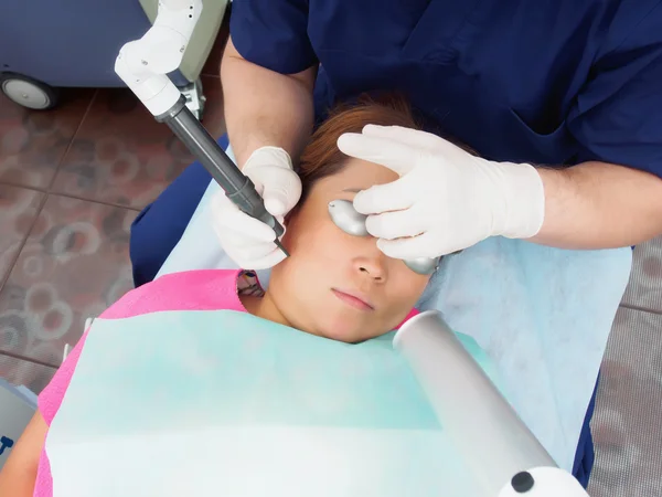 Asian woman patient on laser procedure skin resurfacing in aesthetic medicine.
