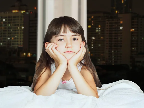 Portrait of caucasian sad girl child kid on background window at night