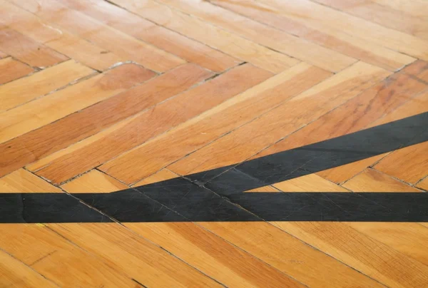 Black lines in hall. Worn out wooden floor of sports hall with colorful marking lines