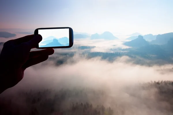 Smart phone mobile photography of sunny rocky mountains landscape, misty spring day