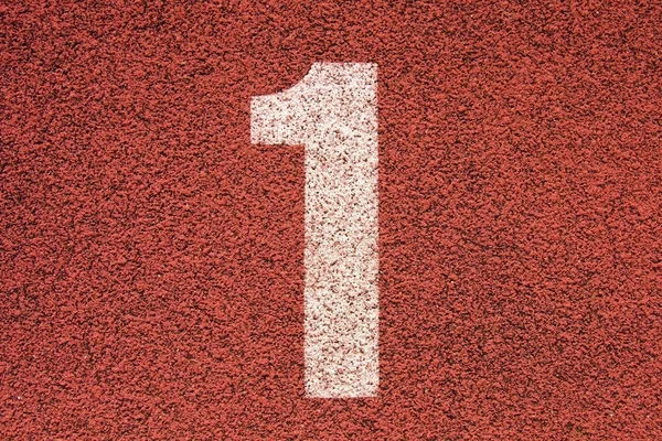 White track number on red rubber racetrack, texture of running racetracks in small outdoor stadium