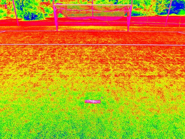Wild colors of thermography photo.  Empty outdoor handball playground, plastic light green surface on ground and white blue bounds lines.