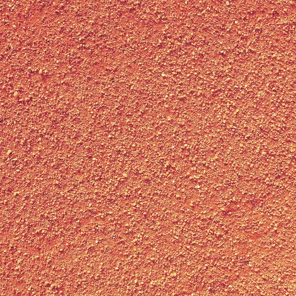 Dry light red crushed bricks surface on outdoor tennis ground. Detail of texture