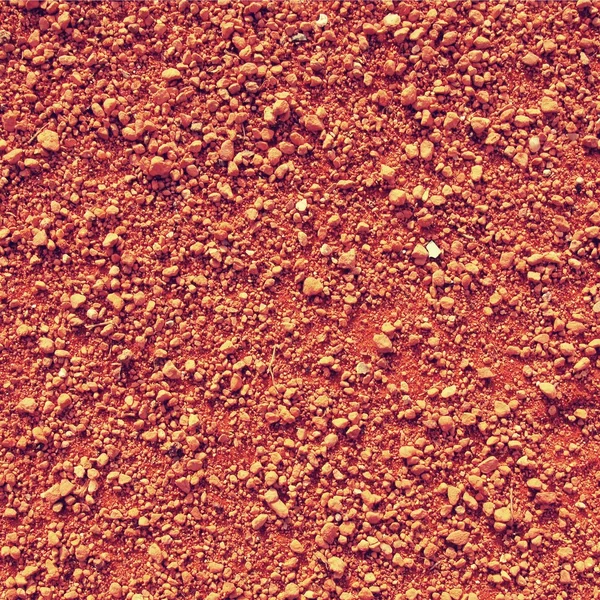 Dry light red crushed bricks surface on outdoor tennis ground. Detail of texture