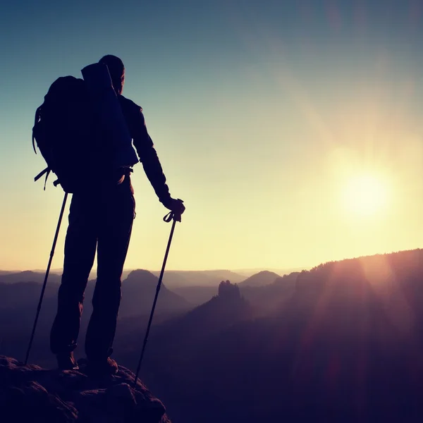 Alone male hiker in mountain landscape at sunset at horizon. Beautiful colorful mountain panorama in the evening in the mountains.