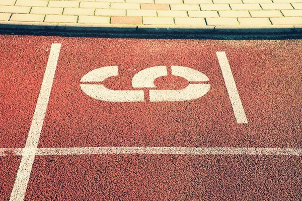Number six. White athletic track number on red rubber racetrack, texture of running racetracks in stadium