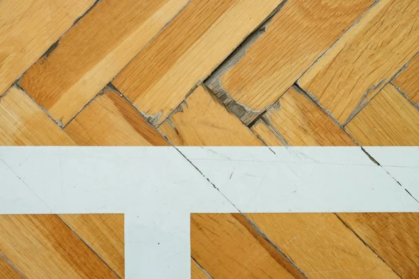 White line in hall . Worn out wooden floor of sports hall with colorful marking lines