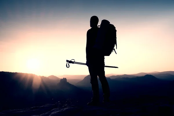 Alone male hiker in mountain landscape at sunset at horizon. Beautiful colorful mountain panorama in the evening in the mountains.