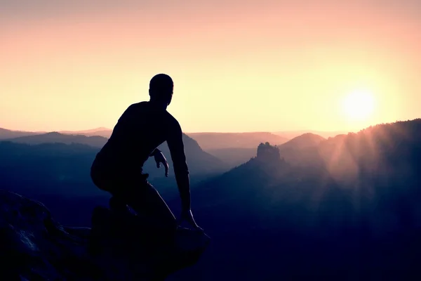 Alone male hiker in mountain landscape at sunset at horizon. Beautiful colorful mountain panorama in the evening in the mountains.