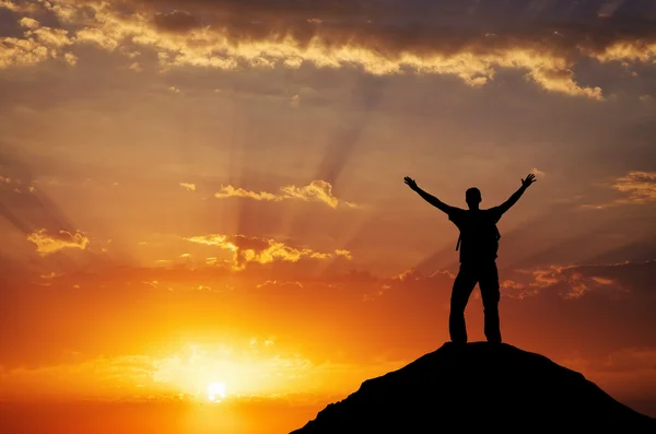 Silhouette of a man on a mountain top.