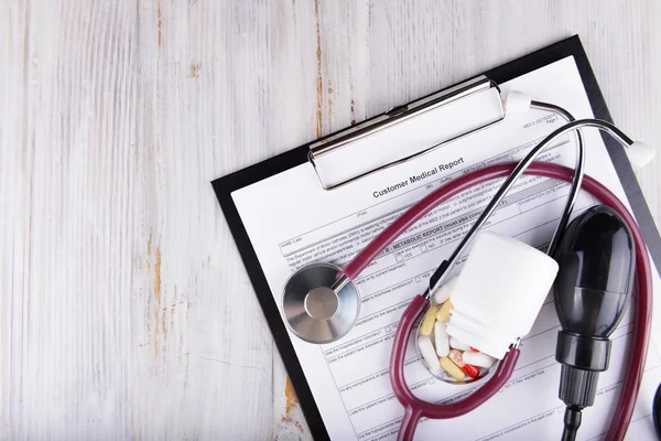 Medical concept of medical report with pills and a stethoscope