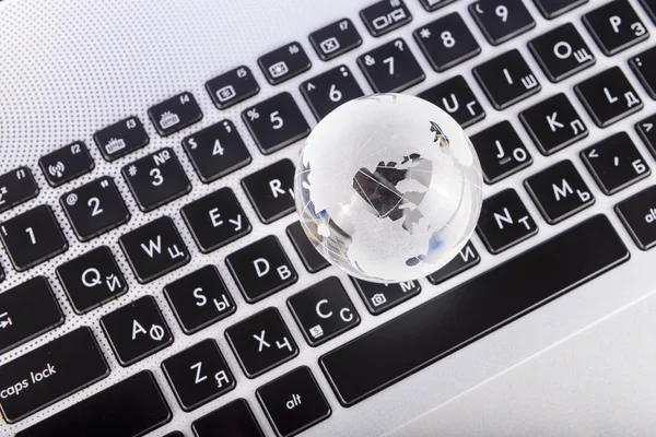 Business concept of a glass globe on a laptop keyboard