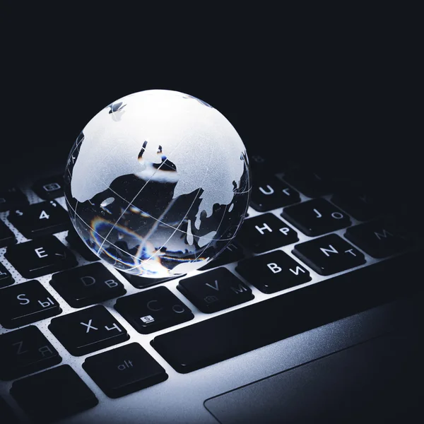 Business concept of a glass globe on a laptop keyboard