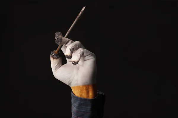 Male hand holds a coffin nail like a cigarette