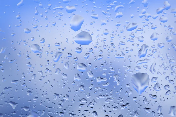 Look at the blue sky through the window with raindrops