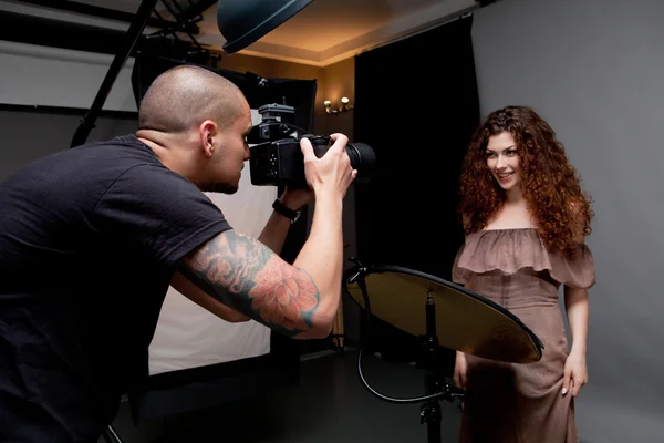Photographer at work with model in the professional studio