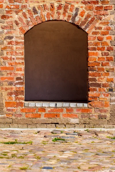 Opening window with arch in brick wall