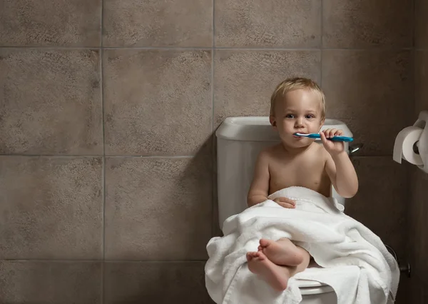 Toddler brushing his teeth after bath