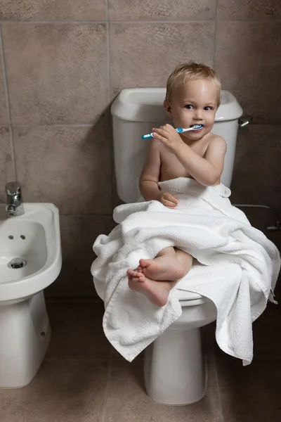 Toddler brushing his teeth after bath