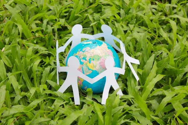 Paper people in a circle with green grass background