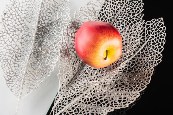 Ripe apple and silver decorative leaves