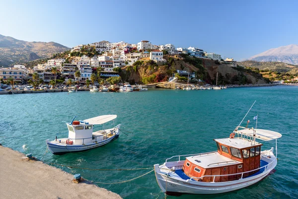 Harbour of Aghia Galini town with parked fishing boats and beautiful houses on the rocks at Crete island, Greece
